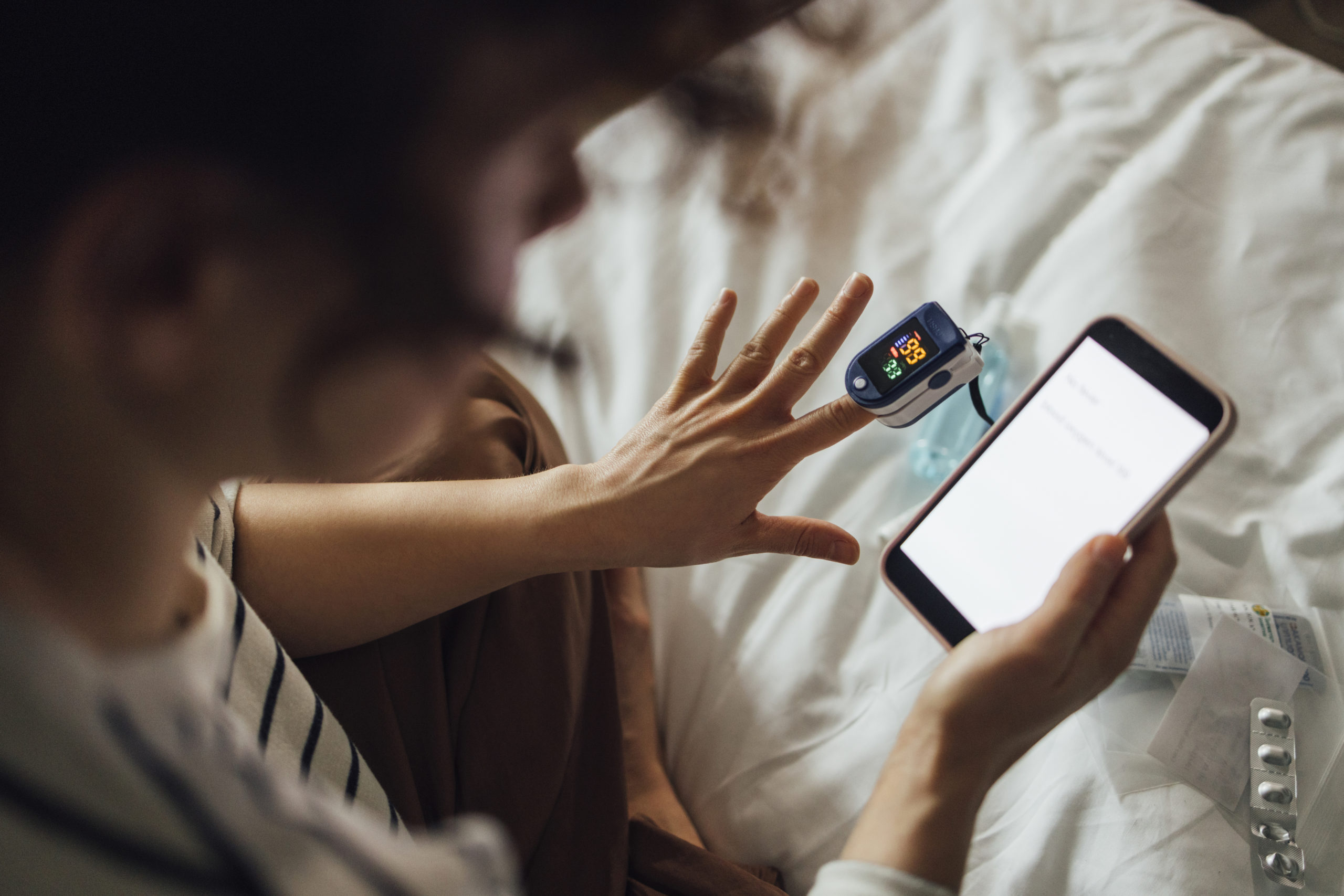 Persona amb telèfon mòbil i pulsioxímetre